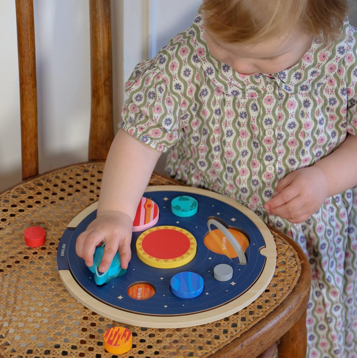 Copil care explorează planeta Pământ pe un puzzle din lemn cu Sistemul Solar de la JucariiAltfel.ro